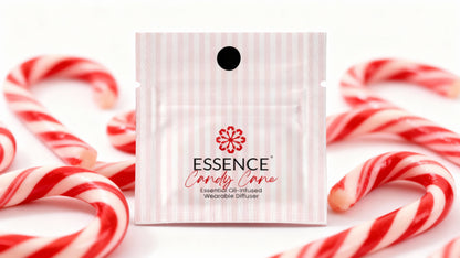 A small white and pink striped sachet labeled ESSENCE Candy Care sits centered on a white background, surrounded by red-and-white candy canes.